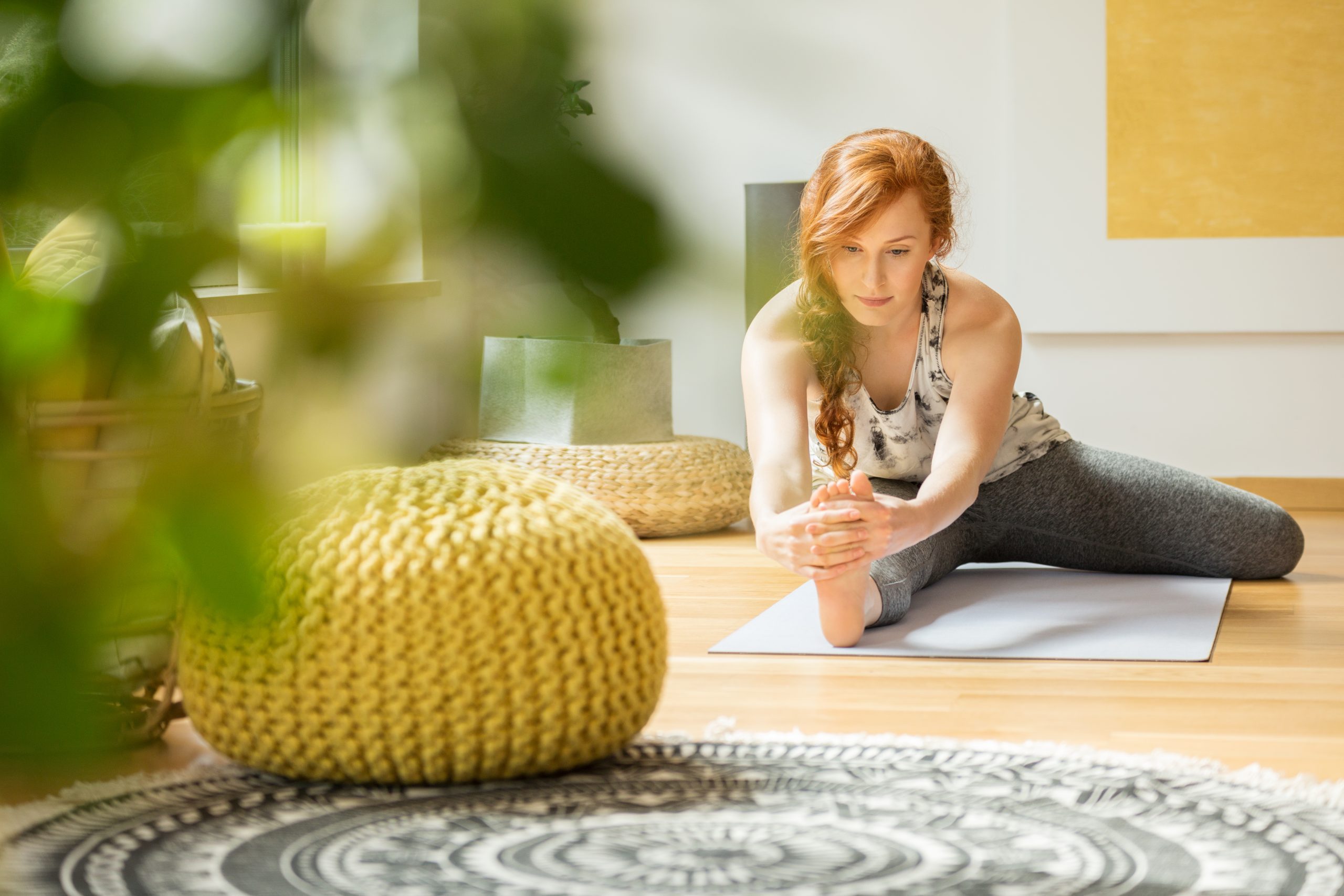Active woman exercising on the floor at her home with yellow decorations